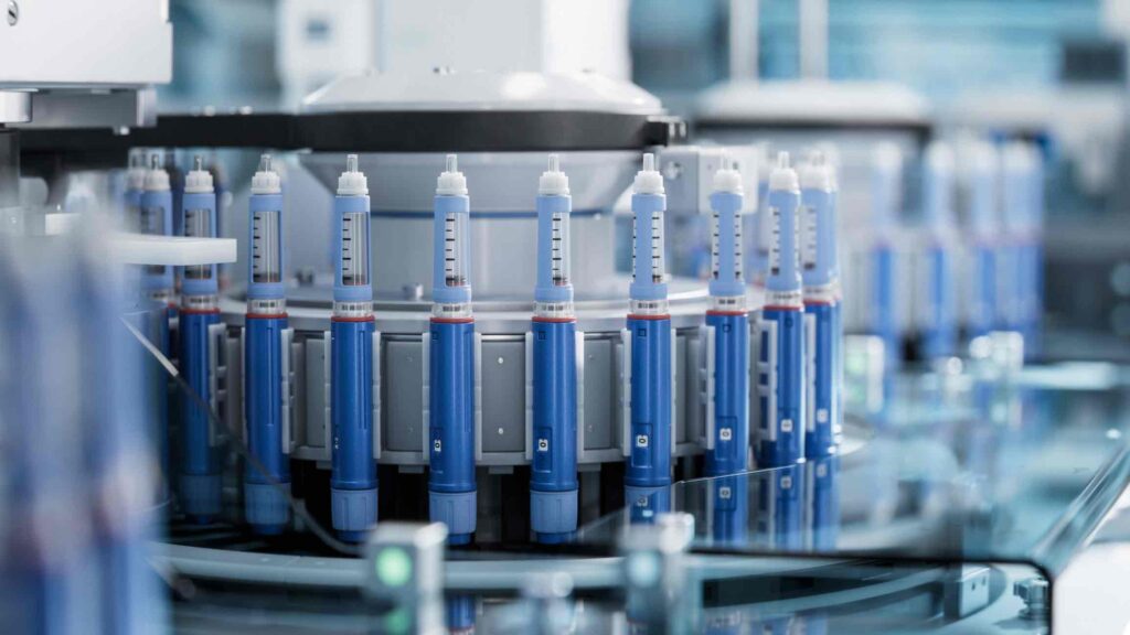Close-up of Medical Injector on Conveyor Line during Production Process at Modern Pharmaceutical Factory. Medical Drug Production Plant. Weight Loss Medication Manufacturing.